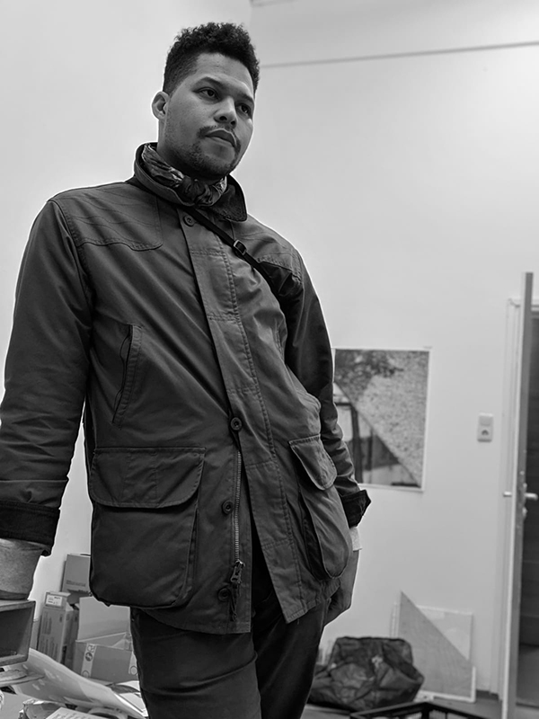 Black and white photograph of Lyndon Barrois Jr. standing in his studio