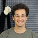 Headshot of Zachary Rapaport in front of a grid mat and with a stuffed monkey
