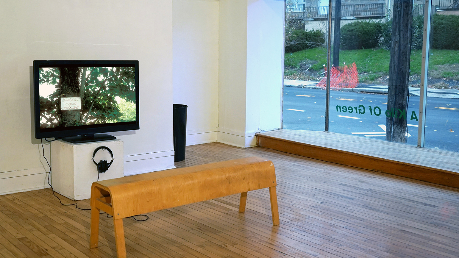 Installation image of The Frame showing a video with bench in front