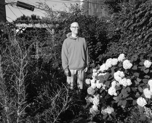 Black and white photograph of Halsey Rodman standing in a garden